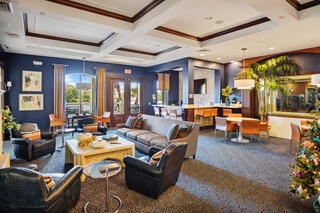 living room with beamed ceiling, ornamental molding, carpet flooring, and coffered ceiling