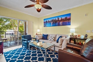 living room featuring ceiling fan and crown molding