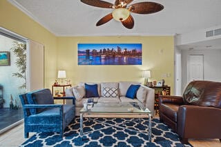 living room featuring ceiling fan and ornamental molding