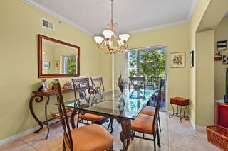 tiled dining area featuring an inviting chandelier and ornamental molding