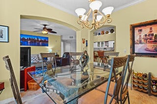 dining area featuring crown molding and ceiling fan with notable chandelier