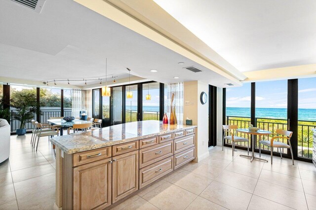 1800 S Ocean Blvd Unit 2A, Boca Raton, FL 33432 - kitchen with expansive windows, a water view, light tile patterned floors, light stone countertops, and decorative light fixtures