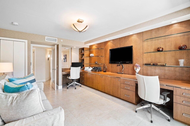 office area with built in desk and light tile patterned floors