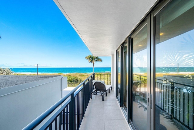 balcony featuring a beach view and a water view