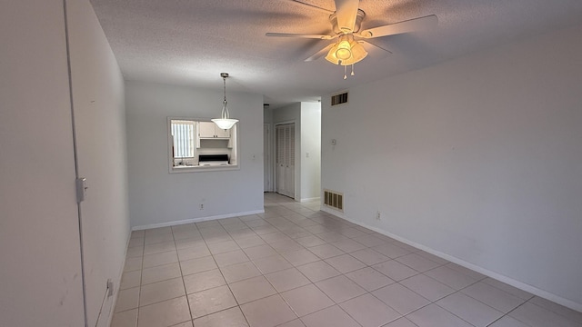 unfurnished room featuring a ceiling fan, visible vents, and a textured ceiling