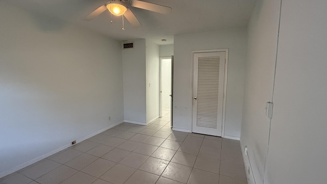 unfurnished bedroom featuring a closet, visible vents, ceiling fan, and light tile patterned flooring