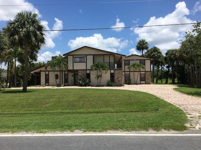 view of front facade featuring a front yard and a balcony