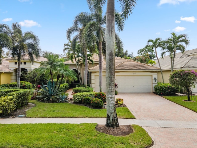 mediterranean / spanish-style house featuring a garage and a front yard