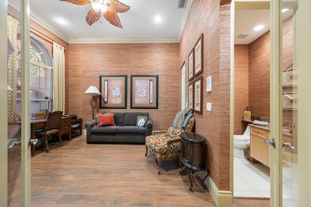 interior space featuring ornamental molding, ceiling fan, french doors, and light hardwood / wood-style floors