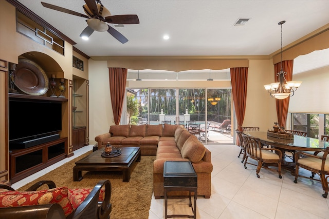 living room with ceiling fan with notable chandelier, light tile patterned floors, and ornamental molding