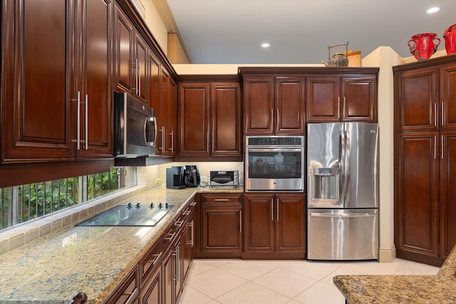 kitchen featuring appliances with stainless steel finishes, decorative backsplash, light stone counters, and light tile patterned floors