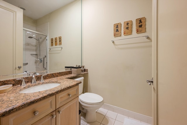 bathroom featuring toilet, vanity, tile patterned floors, and a shower with shower door