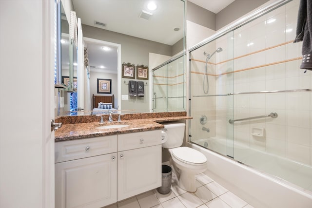 full bathroom with vanity, tile patterned floors, combined bath / shower with glass door, and toilet