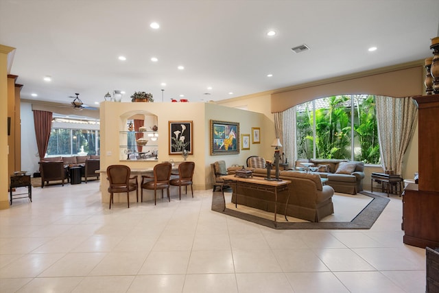 tiled living room featuring ceiling fan and crown molding