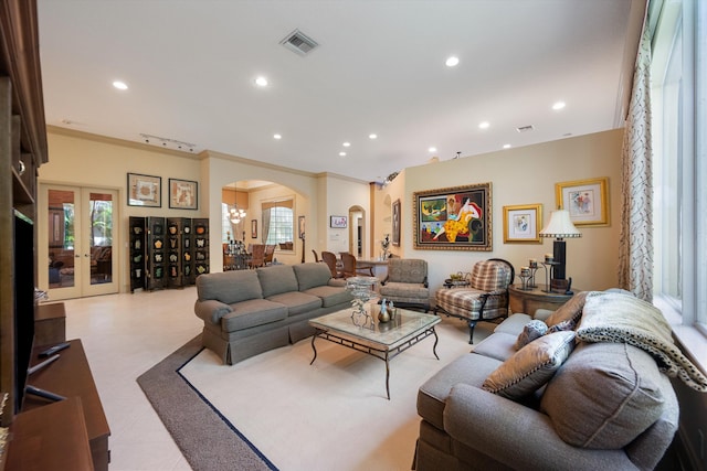 living room with a wealth of natural light, french doors, and crown molding