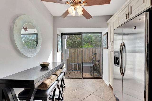 kitchen with stainless steel refrigerator with ice dispenser, ceiling fan, and light tile patterned floors