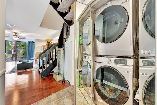 washroom with ceiling fan, wood-type flooring, and stacked washer and dryer