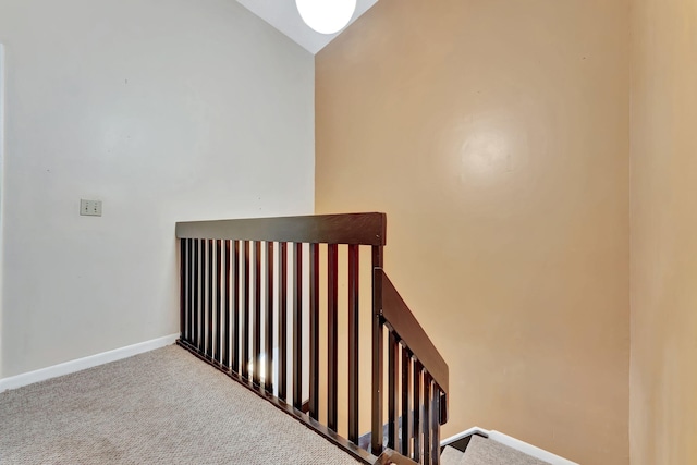 stairway with lofted ceiling and carpet