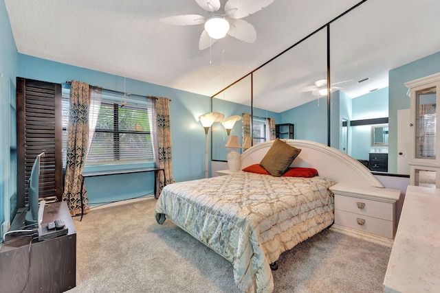 carpeted bedroom featuring ceiling fan and a textured ceiling