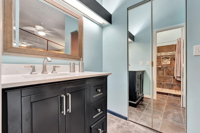 bathroom with walk in shower, vanity, ceiling fan, and tile patterned floors