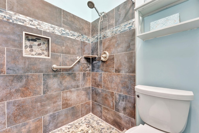 bathroom featuring tiled shower and toilet