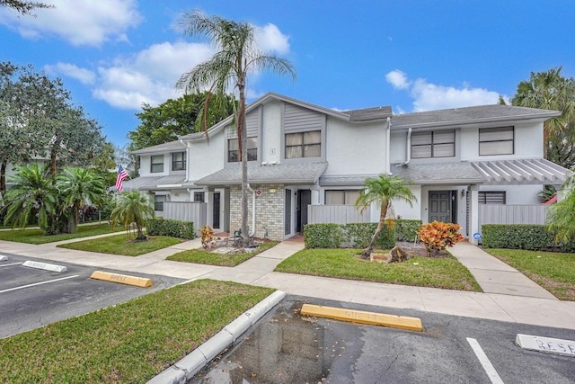 townhome / multi-family property featuring a front lawn