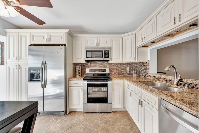 kitchen featuring sink, tasteful backsplash, light tile patterned floors, light stone countertops, and appliances with stainless steel finishes