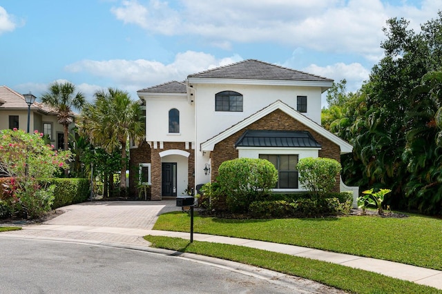 mediterranean / spanish home with a front lawn