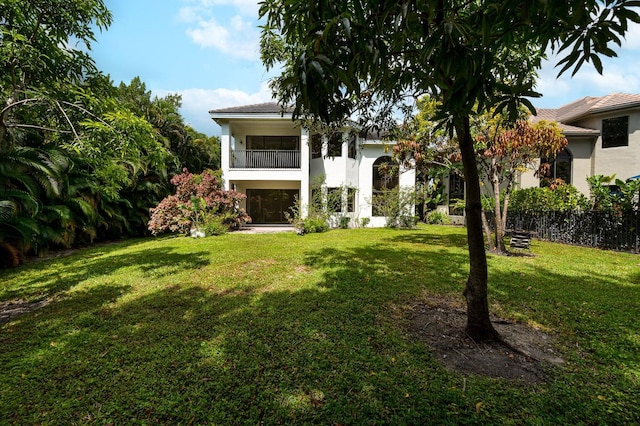 exterior space with a balcony and a lawn