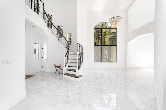 foyer with a towering ceiling and a notable chandelier