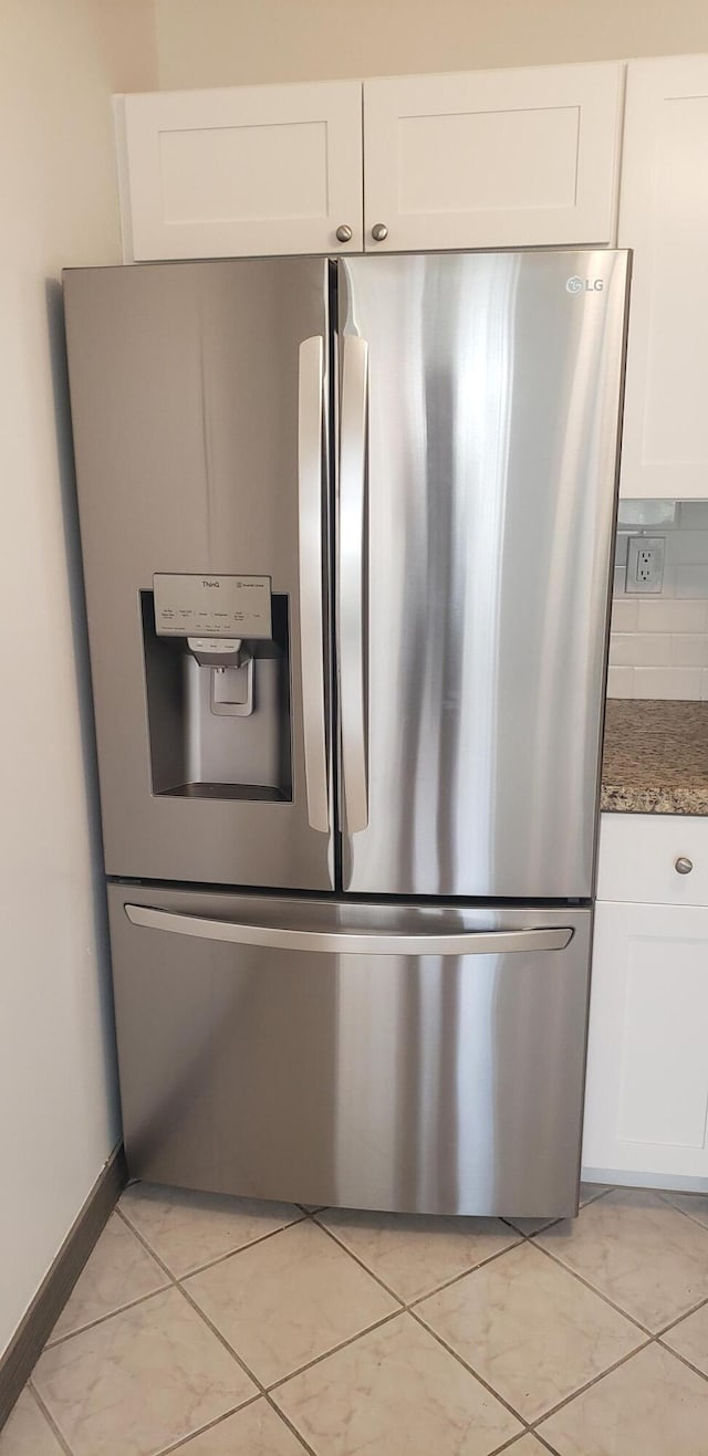 details with white cabinetry, stainless steel refrigerator with ice dispenser, and backsplash