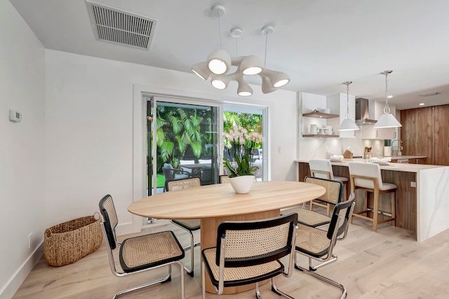 dining space featuring light hardwood / wood-style flooring and a chandelier