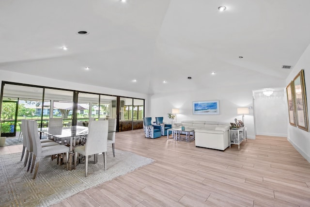 dining room featuring light hardwood / wood-style floors and vaulted ceiling