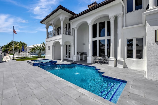 view of swimming pool featuring pool water feature, an in ground hot tub, and a patio area