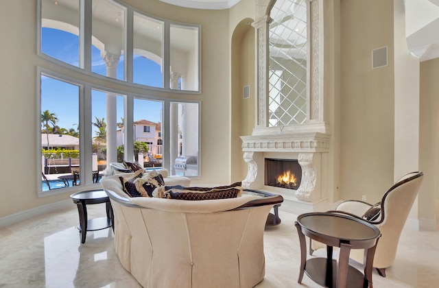 living room with a high ceiling and a high end fireplace