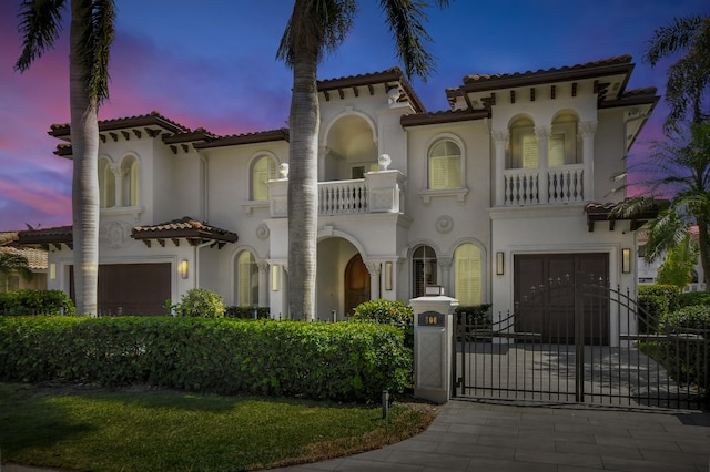 mediterranean / spanish home featuring a garage and a balcony