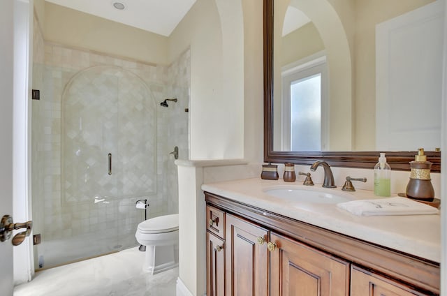 bathroom featuring toilet, vanity, and a shower with shower door