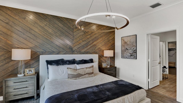 bedroom featuring crown molding, wood walls, and dark hardwood / wood-style floors