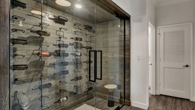 bathroom with ornamental molding, hardwood / wood-style flooring, and an enclosed shower