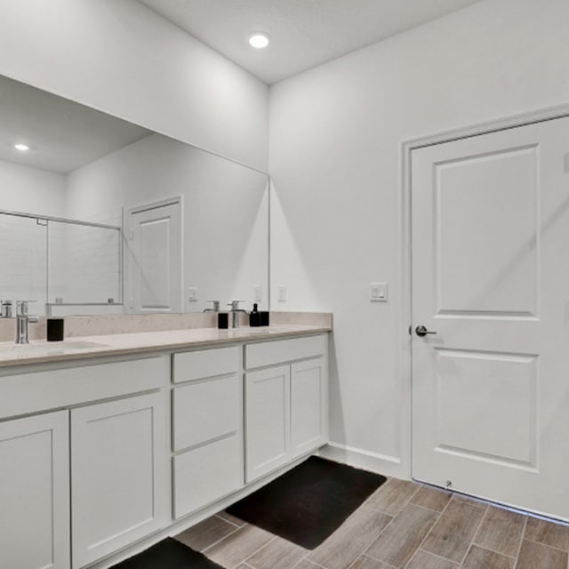 bathroom with vanity and a shower with shower door