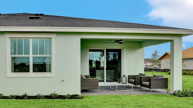 rear view of property with an outdoor living space, a patio, a lawn, and ceiling fan