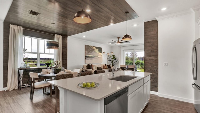 kitchen with an island with sink, stainless steel appliances, sink, pendant lighting, and white cabinets