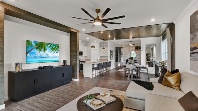 living room featuring crown molding, ceiling fan, and dark hardwood / wood-style flooring