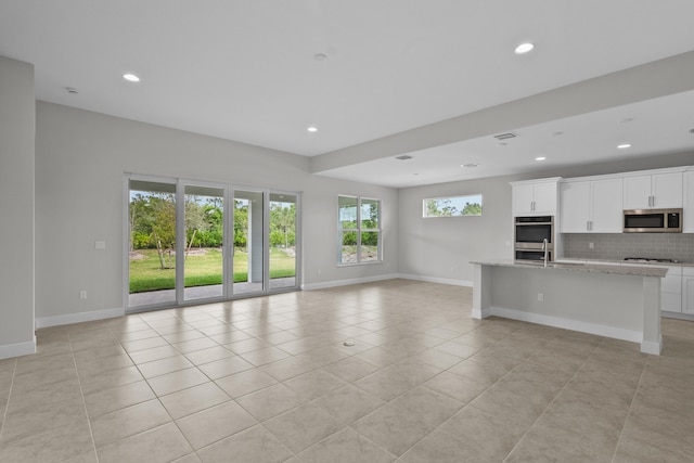 unfurnished living room with sink and light tile patterned floors