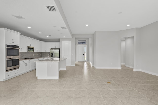 kitchen with light tile patterned flooring, white cabinetry, a kitchen island with sink, and stainless steel appliances