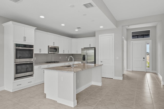 kitchen featuring white cabinets, a kitchen island with sink, stainless steel appliances, and sink