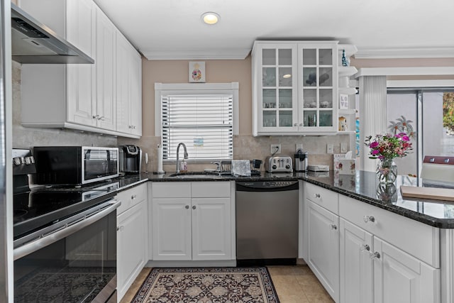 kitchen featuring white cabinetry, appliances with stainless steel finishes, wall chimney range hood, and plenty of natural light