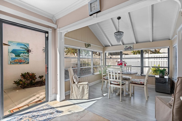 sunroom with plenty of natural light and vaulted ceiling with beams