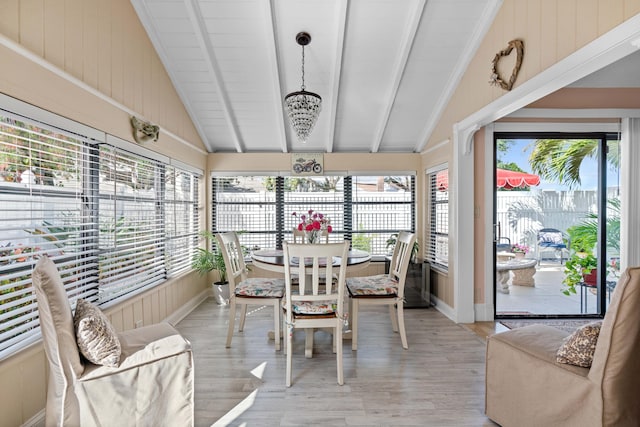 sunroom featuring lofted ceiling with beams