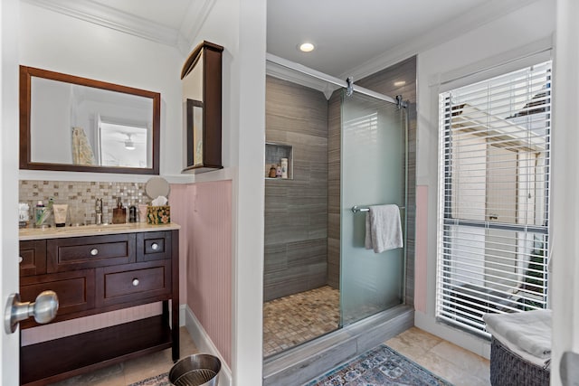 bathroom with tasteful backsplash, vanity, crown molding, and a shower with shower door